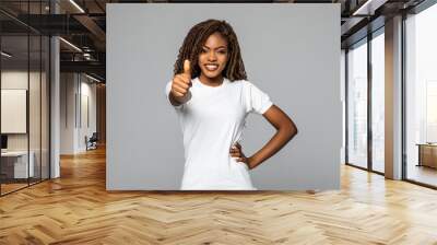 Pretty African American woman with thumb up isolated on white background Wall mural